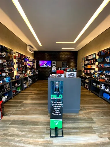 Interior da loja MLD Assistência Técnica mostrando balcão de atendimento, equipamentos de diagnóstico e área de espera com iluminação moderna